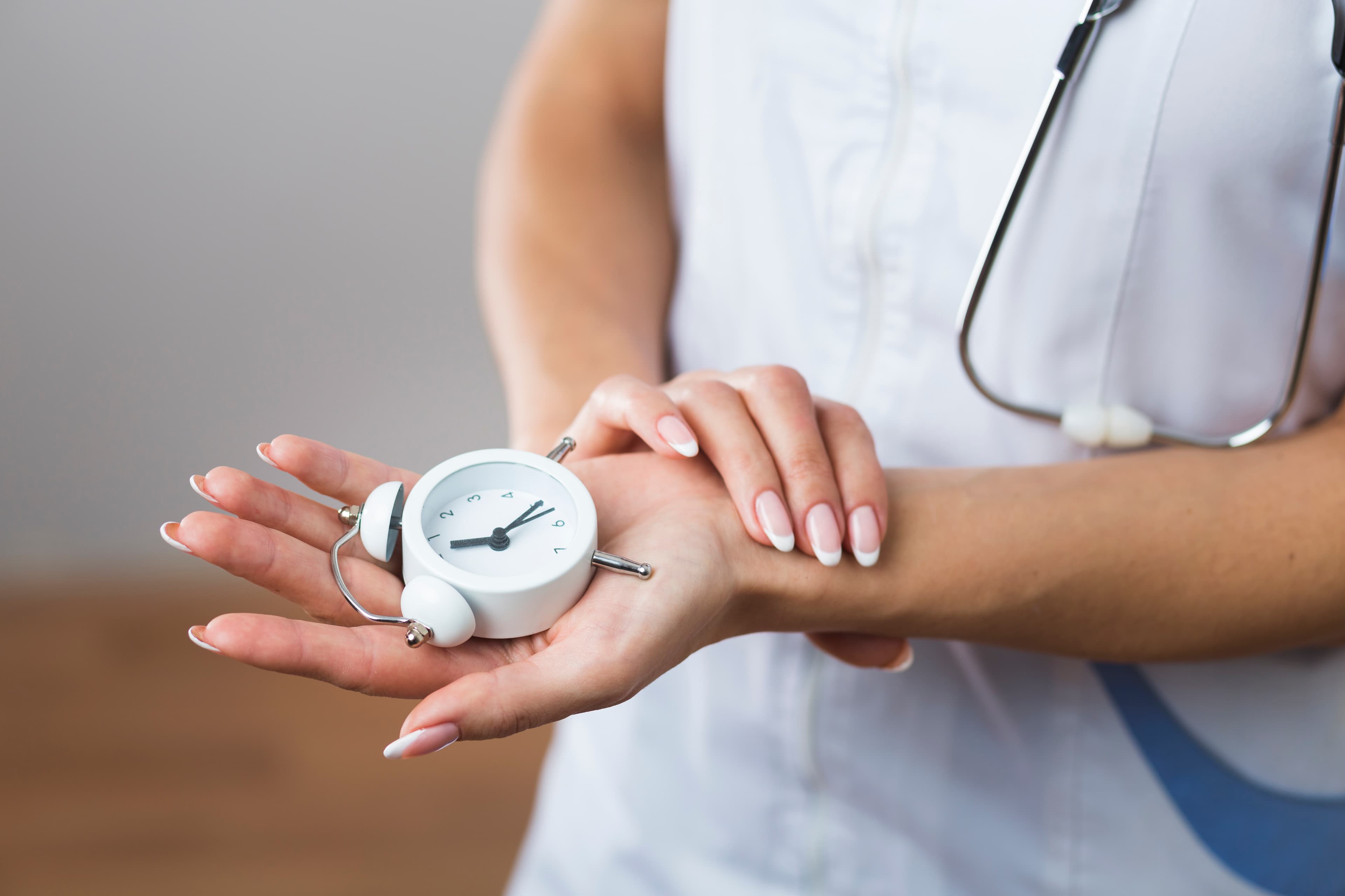 Woman holding a small clock in her hands