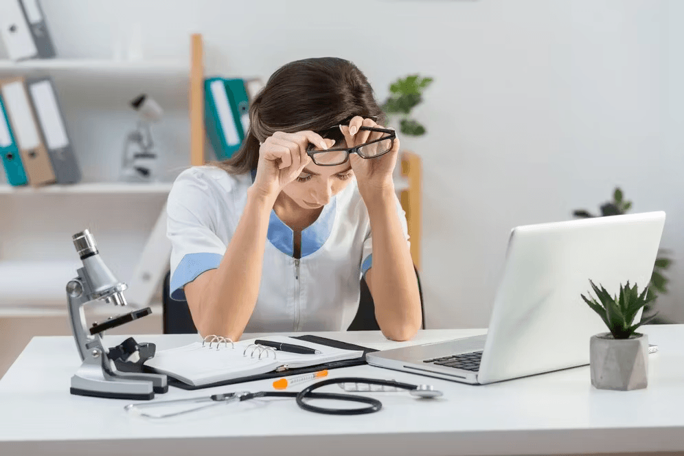 Tired female doctor taking off her glasses